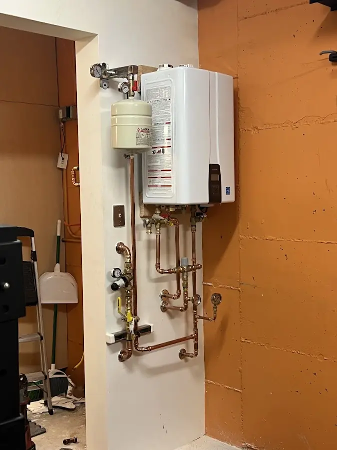 Plumbing technician inspecting water heater connections in Saraland